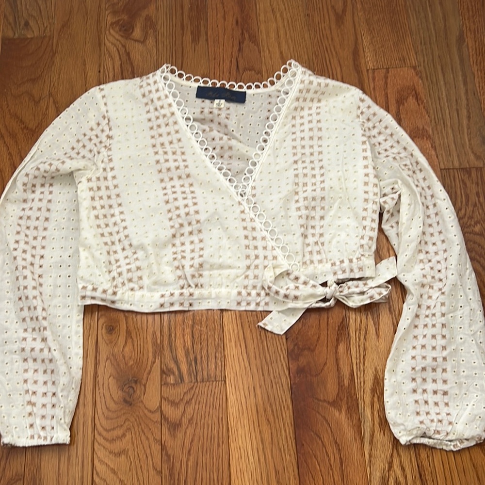Cute wrap top from franchescas that is white with neutral colored embroidery